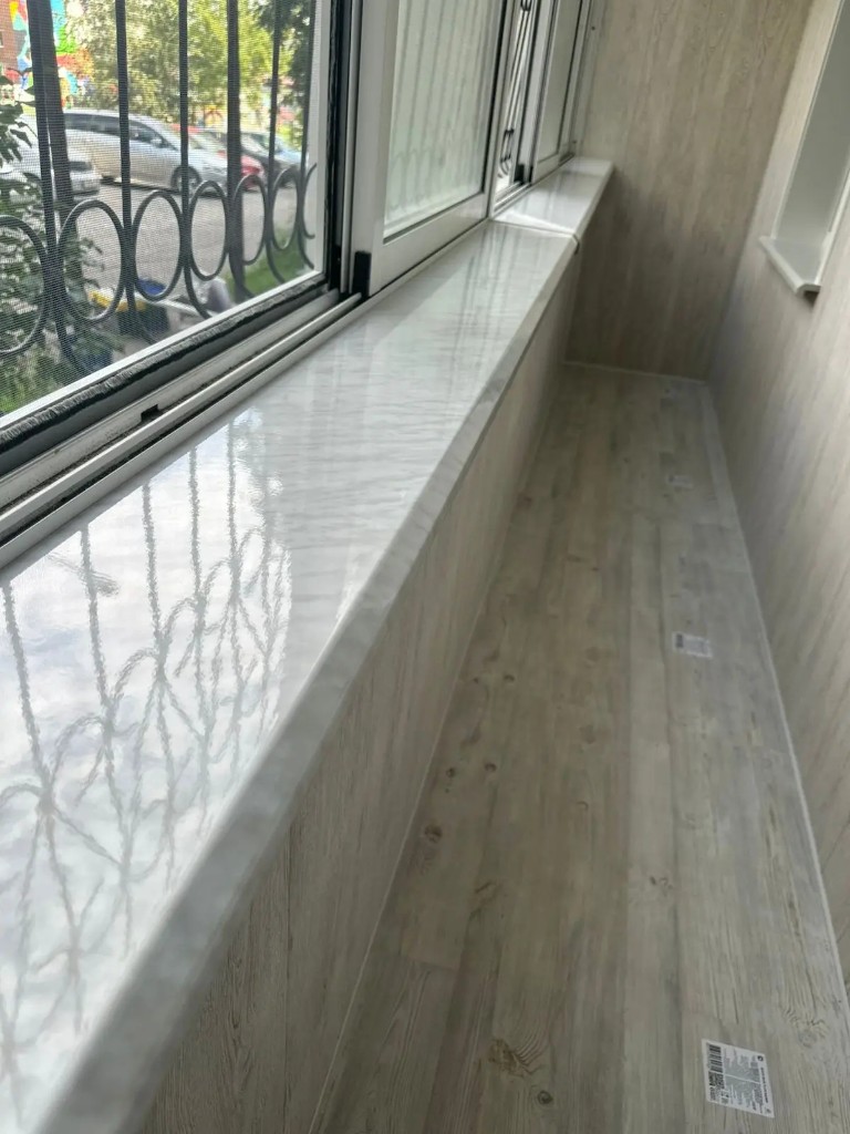 Фасад многоэтажного дома с белым остеклением балконов